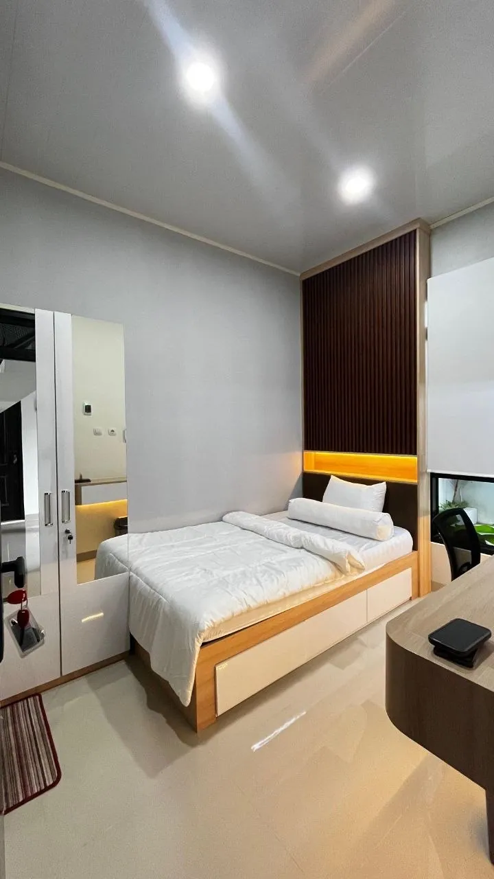 Kamar tidur dengan ranjang, panel kayu, dan lampu tanam